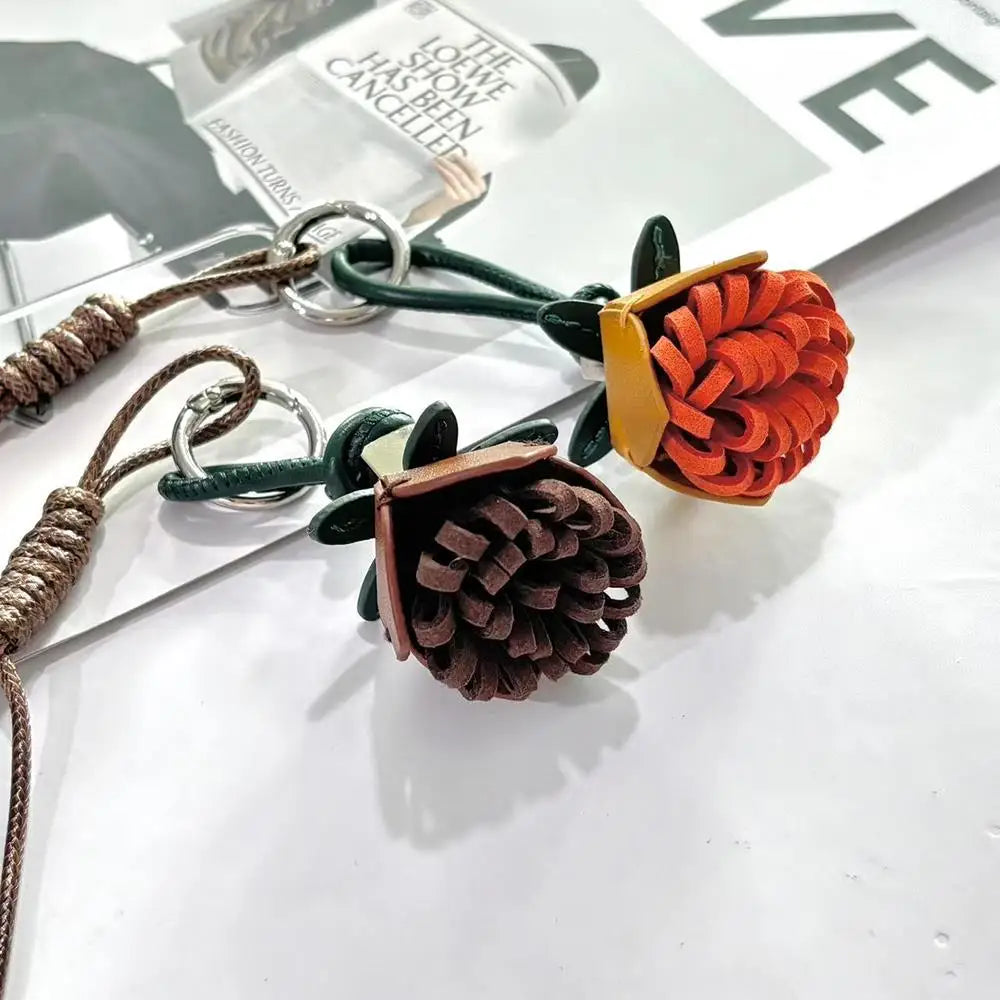 Breloque de sac à main avec pompon fleuri pour femme, porte-clés haut de gamme en cuir PU, pendentif en corde tressée avec pomme de pin et fleur.