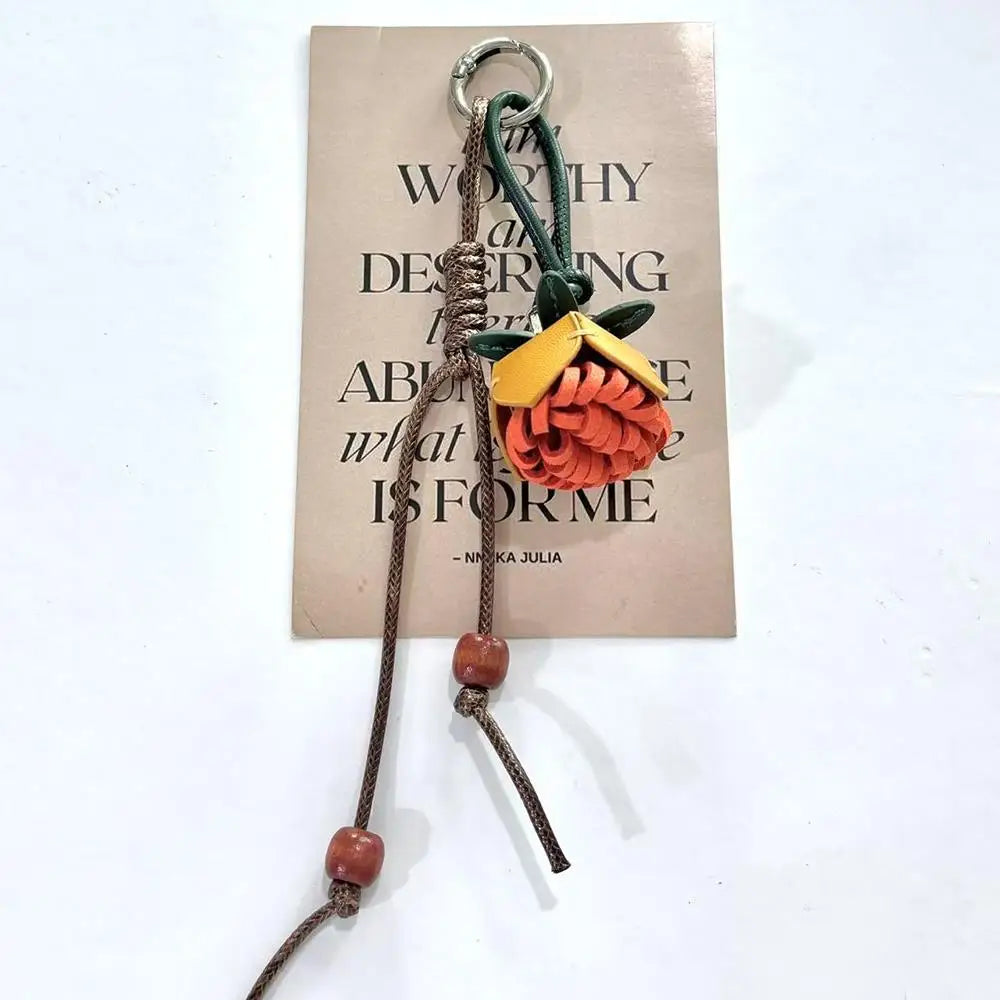 Breloque de sac à main avec pompon fleuri pour femme, porte-clés haut de gamme en cuir PU, pendentif en corde tressée avec pomme de pin et fleur.