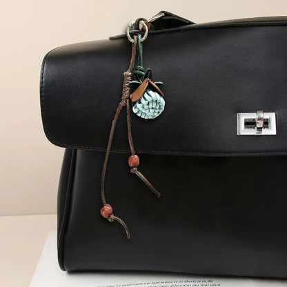 Breloque de sac à main avec pompon fleuri pour femme, porte-clés haut de gamme en cuir PU, pendentif en corde tressée avec pomme de pin et fleur.