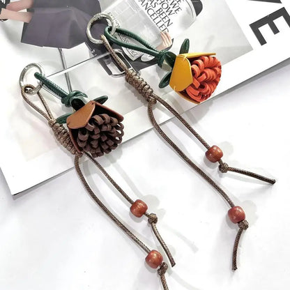 Breloque de sac à main avec pompon fleuri pour femme, porte-clés haut de gamme en cuir PU, pendentif en corde tressée avec pomme de pin et fleur.