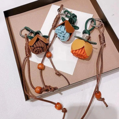 Breloque de sac à main avec pompon fleuri pour femme, porte-clés haut de gamme en cuir PU, pendentif en corde tressée avec pomme de pin et fleur.